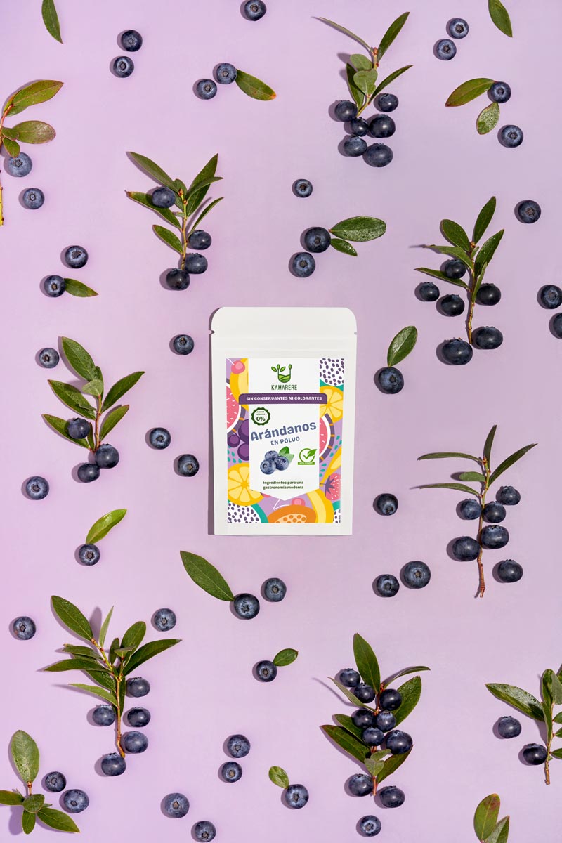 Captivating flat lay photograph featuring a white packaging filled with a finely powdered blend of fresh seasonal ingredients. Surrounding the packaging, you'll find juicy blueberries. This exquisite studio product photography showcases the essence of the Kamarere food brand.