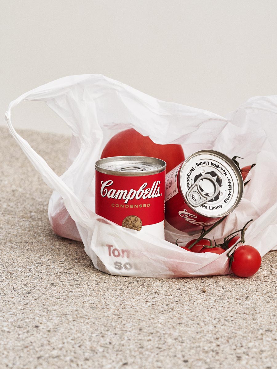 Still life photography of Campbell’s Tomato Soup with fresh tomatoes by Irina Lokteva Pikalova (Irina Lopik), blending iconic branding with natural elements in a contemporary outdoor setting.