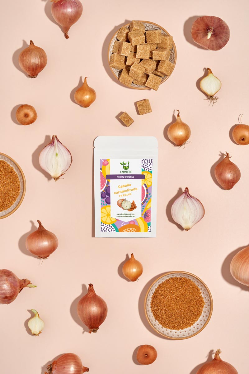 Captivating flat lay photograph featuring a white packaging filled with a finely powdered blend of fresh seasonal ingredients. Surrounding the packaging, you'll find onion and sugar used in the process of production of the powder. This exquisite studio product photography showcases the essence of the Kamarere food brand.