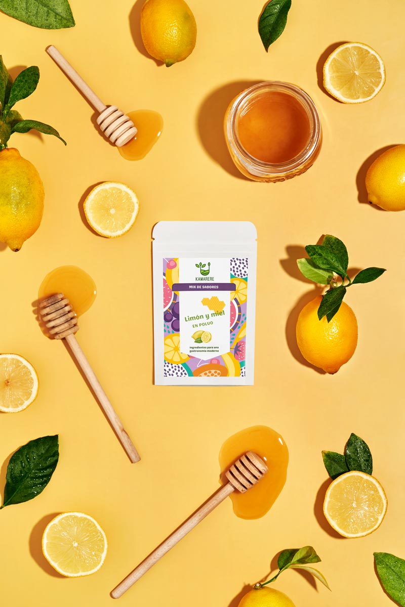 Captivating flat lay photograph featuring a white packaging filled with a finely powdered blend of fresh seasonal ingredients. Surrounding the packaging, you'll find juicy lemon and a honey jar. This exquisite studio product photography showcases the essence of the Kamarere food brand.