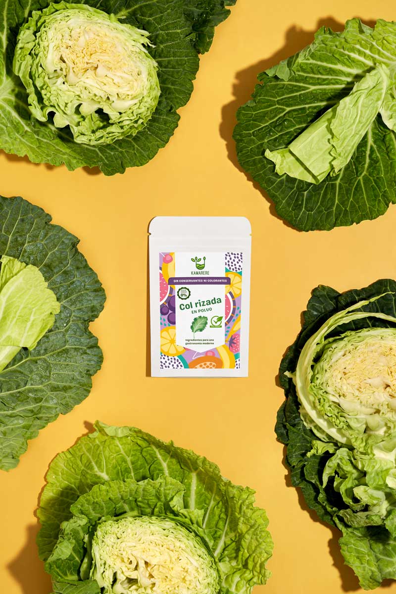 Captivating flat lay photograph featuring a white packaging filled with a finely powdered blend of fresh seasonal ingredients. Surrounding the packaging, you'll find fresh kale. This exquisite studio product photography showcases the essence of the Kamarere food brand.