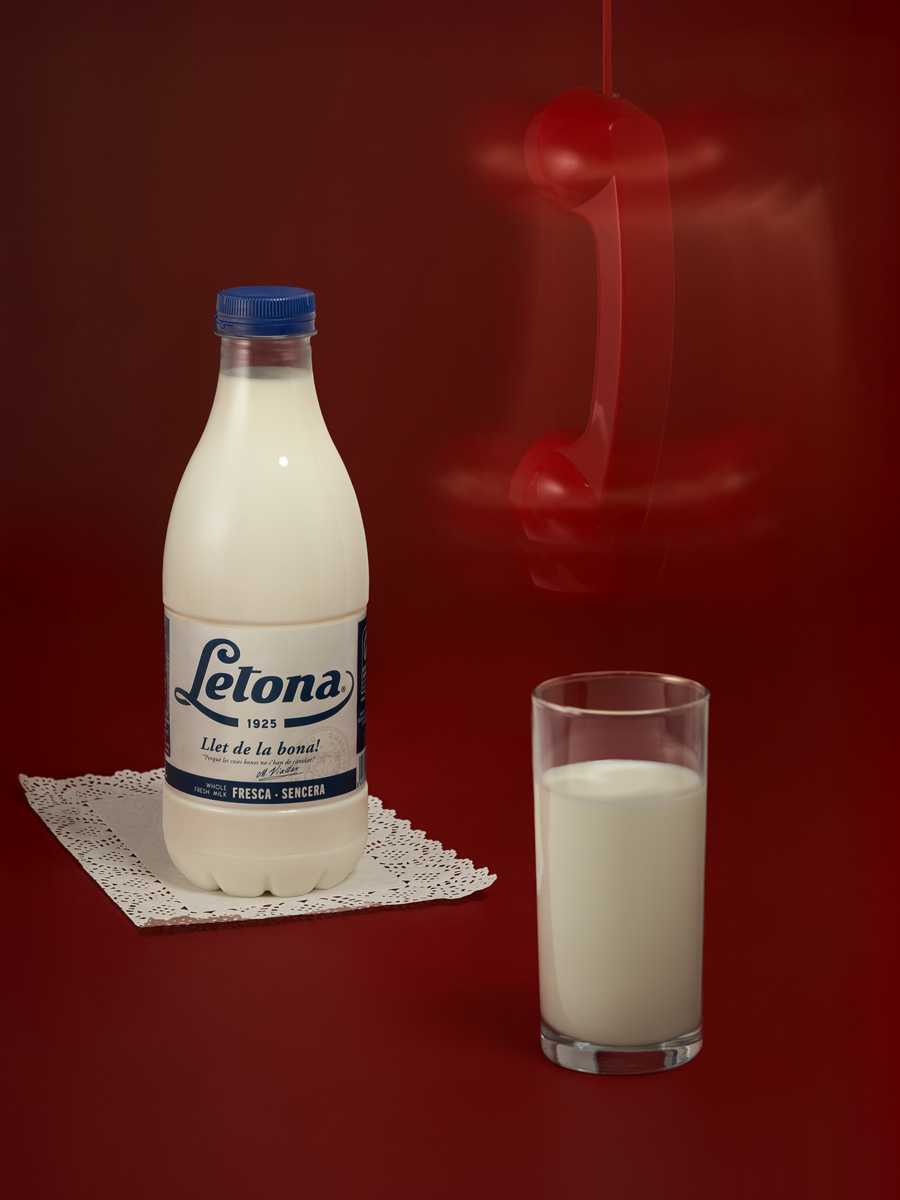 A stylized product portrait of Letona milk featuring nostalgic design elements and a surreal, minimal red backdrop with a suspended telephone receiver. By Irina Lokteva Pikalova (Irina Lopik)