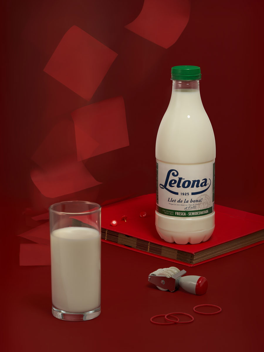 A stylized product portrait of Letona milk featuring nostalgic design elements and a surreal, minimal red backdrop with a suspended telephone receiver. By Irina Lokteva Pikalova (Irina Lopik)