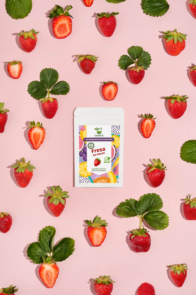 Captivating flat lay photograph featuring a white packaging filled with a finely powdered blend of fresh seasonal ingredients. Surrounding the packaging, you'll find juicy strawberries. This exquisite studio product photography showcases the essence of the Kamarere food brand.